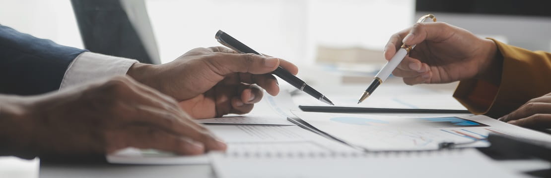 View of two sets of hands reviewing documents on a table.